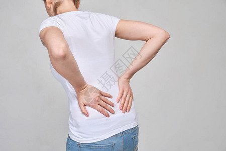 穿着白色T恤的女孩从重度疼痛的背部向下按摩静图片