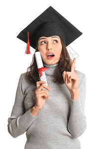 获得文凭和白种背景提高食指的毕业女毕业生图片