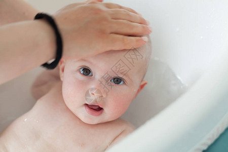 小婴儿正在由他的母亲洗澡洗澡图片
