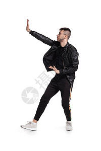 一位戴着眼镜黑色皮夹克T恤运动裤和轻便运动鞋的现代表演者在工作室里鬼混的全长照片一位时尚男跳舞和打手背景图片