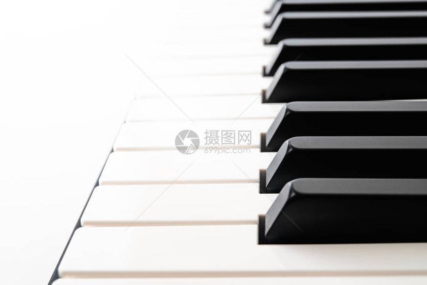 将钢琴键盘关闭在白背景上图片