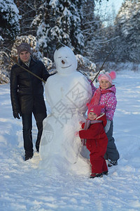 冬天孩子们在森林里堆雪人图片