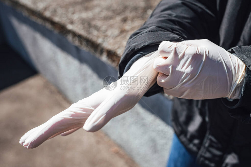 妇女戴上塑料医疗手套来保护年龄在Corona图片