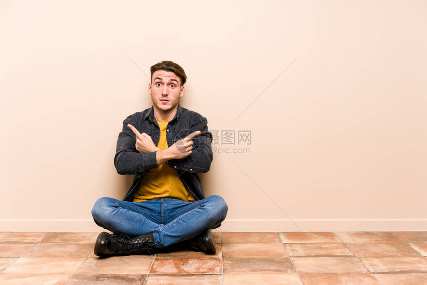 坐在地上与世隔绝的偏僻点边缘的年轻天主教男子正试图在两种选择图片