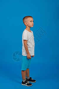 一个穿白色T恤和蓝短裤的可爱5岁男孩图片