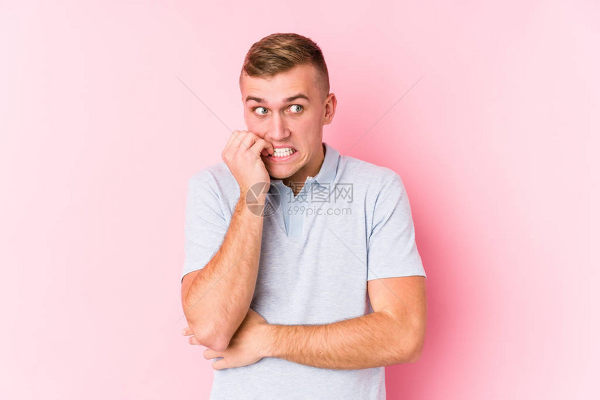 年轻的caucasian男子孤立的咬指甲图片
