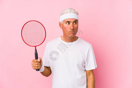 玩羽毛球的中年男子孤立地感到困惑感到图片