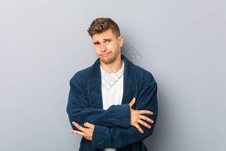 年轻caucasian男子身着睡衣不开心的外表图片