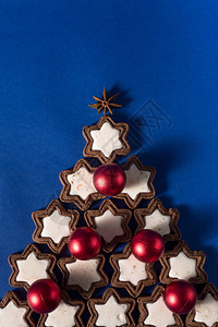 2020年新替代圣诞树自制饼干圣诞树装饰球躺在蓝色背景上特写图片