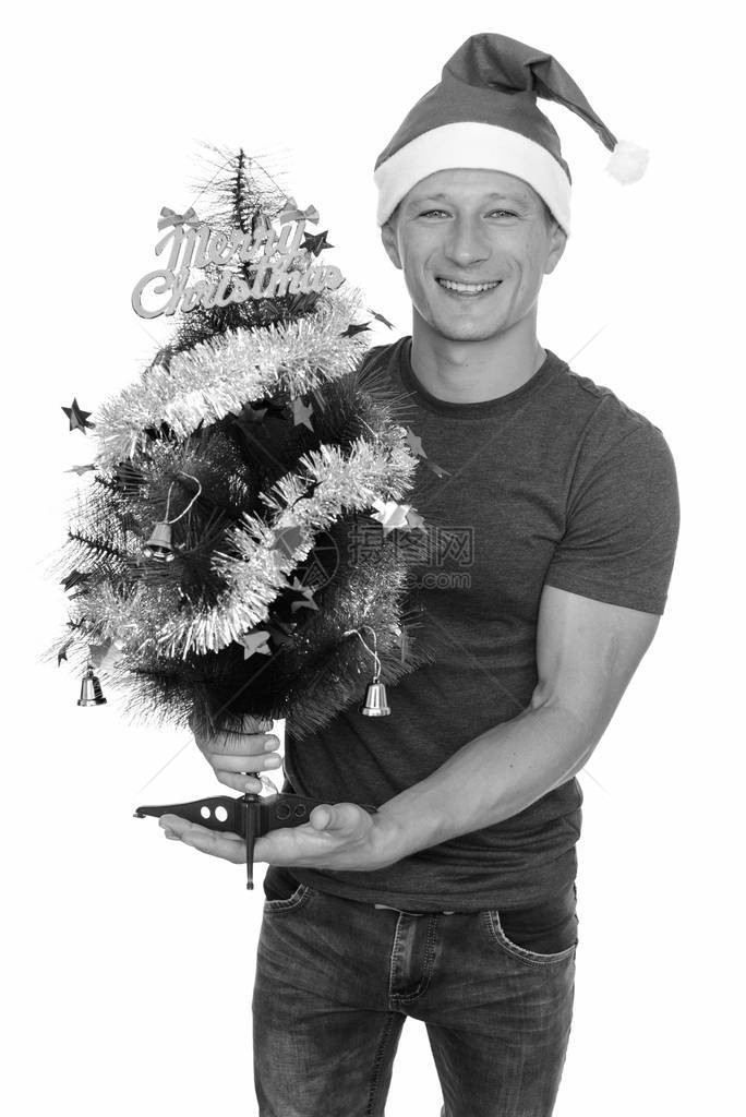 电影演播室拍摄的年轻英俊男子准备迎接圣诞节在白黑背图片