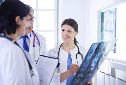 微笑的医生讨论病人诊断时在医院看X光片图片