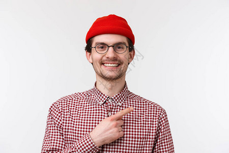特写肖像英俊友好的时髦男穿着红色无檐小便帽和眼镜图片