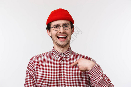 特写肖像吹嘘滑稽的胡子年轻人在红色无檐小便帽和眼镜图片