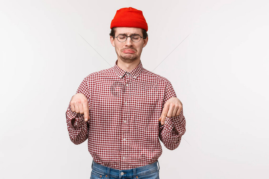 腰部向上肖像心疼和心烦抱怨年轻心烦意乱的家伙在红色无檐小便帽图片