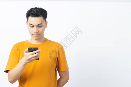 年轻快乐的亚洲男子阅读来自智能手机的信息复制空间图片