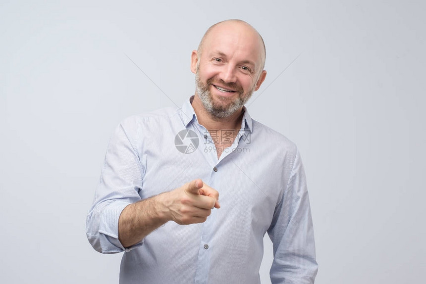 成熟的笑英俊兴奋快乐的男人用手指着你的相机手势图片