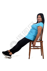 一个女人坐在白色背景的椅子上放松图片