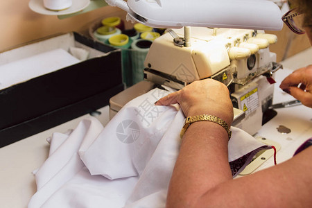 一位老年妇女在缝纫机上缝衣裁缝刺绣制成品退休后从事最喜图片