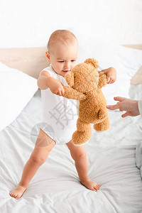 赤脚长着白衣服的可爱孩子在床上背景图片