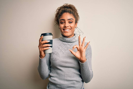 年轻的非洲裔美国黑人女孩在白色背景下喝杯外卖咖啡图片