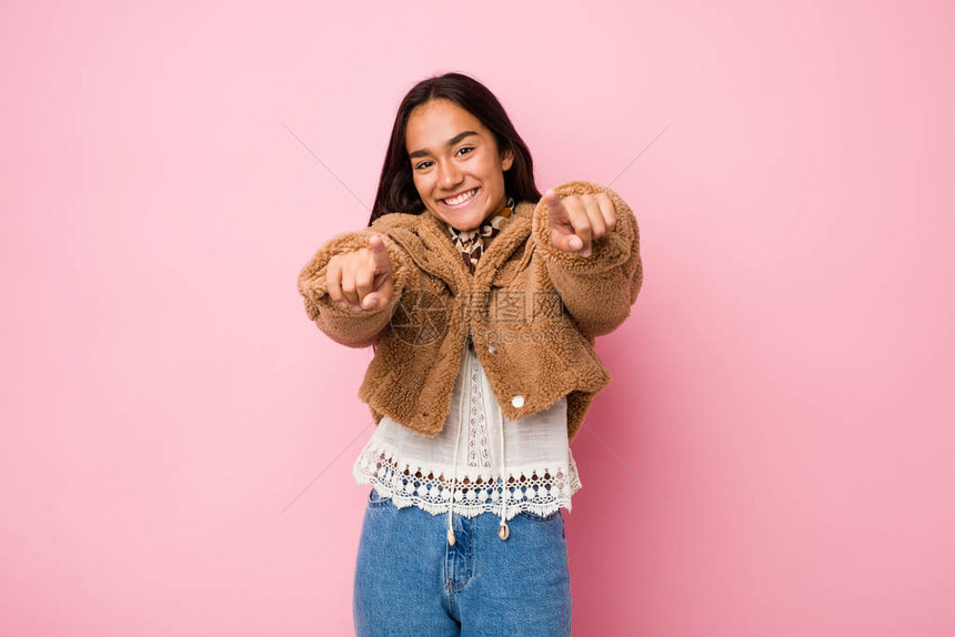 身穿短绵羊皮大衣微笑的印度裔年轻混血女子在图片