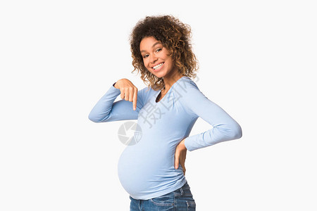 令人兴奋的孕妇用手指肚子指着腹部图片