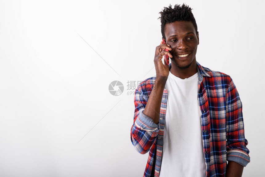 演播室拍摄年轻快乐的黑人非洲男子在白人背景下思考和谈论手机时笑图片