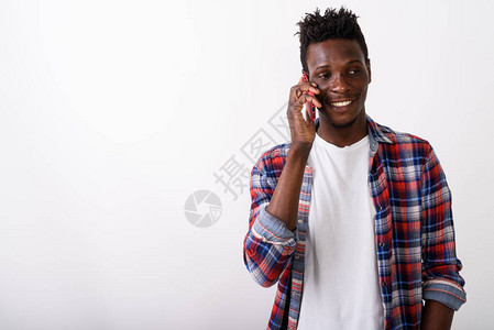 演播室拍摄年轻快乐的黑人非洲男子在白人背景下思考和谈论手机时笑图片