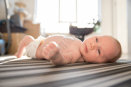 一个身着白尿布的新生婴儿躺在背上图片