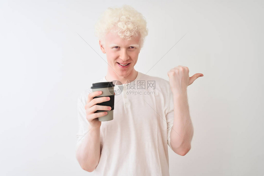 年轻的白黄金发男子喝咖啡站在孤立的白色背景下指着点图片