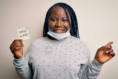 身戴医疗面具的非洲美妇女带着警报信息提醒的警讯图片