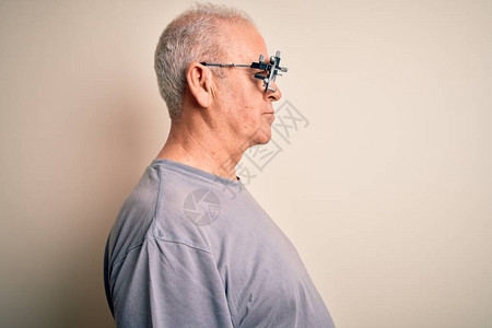 中年男修士控制视线身穿白底的光学眼镜一边看一边放松姿势带着自然面孔满图片