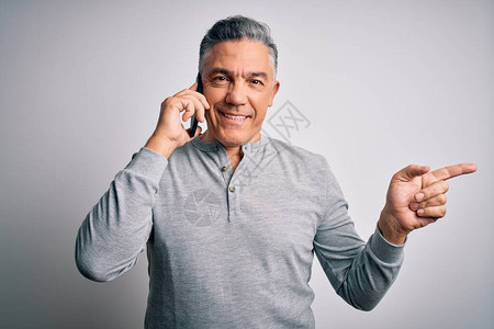 中年人英俊的灰发男子在智能手机上聊天非常开心地用手和指图片