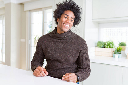 身穿冬季毛衣的非裔美国人带着笑容和自然表情往一边看图片