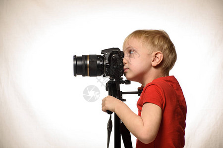 Blond男孩用SLR相机拍照侧视图图片