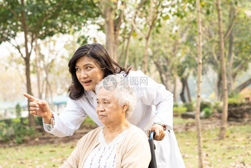 医生帮助和照顾坐在护理医院病房轮椅上的亚洲老年或老年妇人患者图片