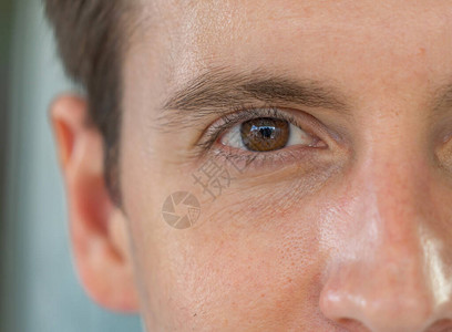 英俊的西方人面部皮肤特写镜头男眼睛可以看到深褐色眼睛的纹理宏观图片