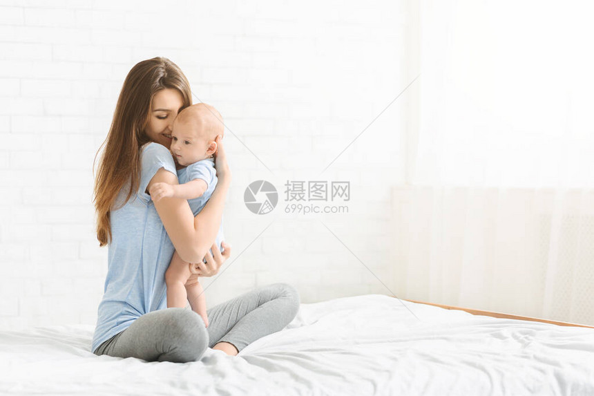 年轻女与新生婴儿相亲在一起的肖像图片