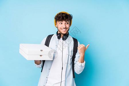 年轻阿拉伯学生男子拿着披萨图片