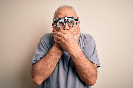 中年男子控制视线时戴着白色背景的光学眼镜图片