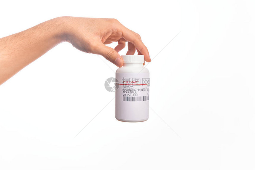 在孤立的白种背景上拿着一瓶药丸的天图片