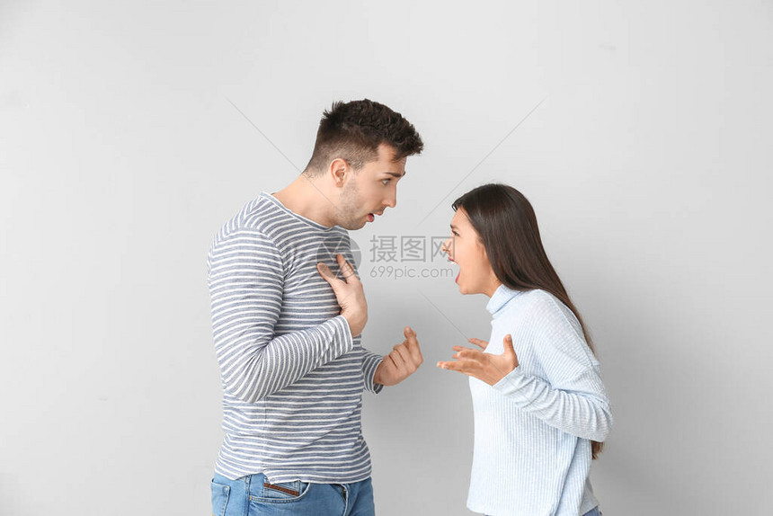 浅色背景下吵架的年轻夫妇图片