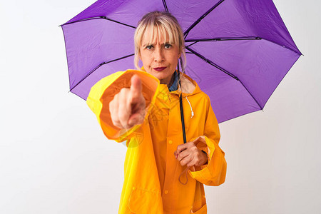 中年妇女穿着雨衣和紫色雨伞图片