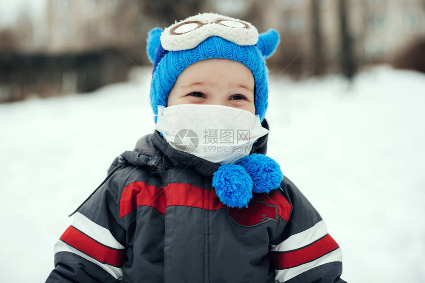 冬季在街上戴医疗面具的一名男孩的肖像图片