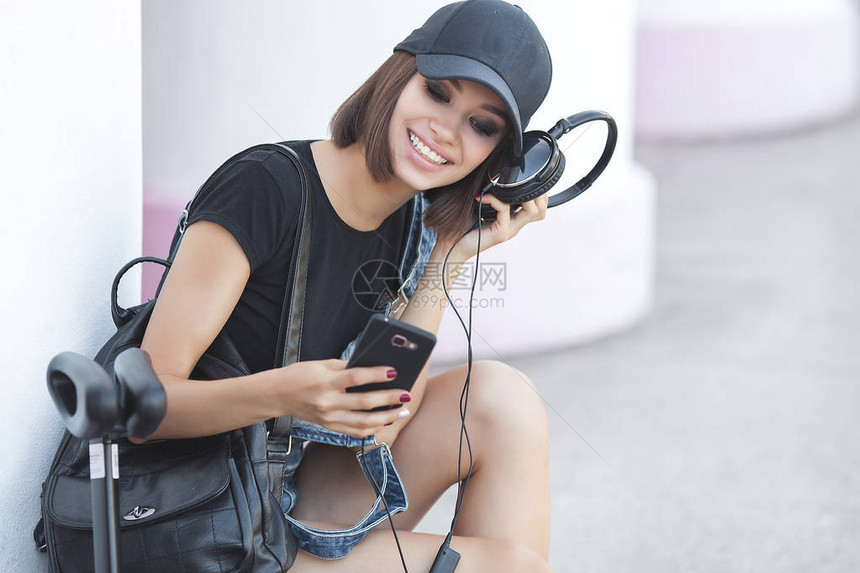 具有中背景的拥有各种工具的妇女现代青年轻女在智能手机上聆图片