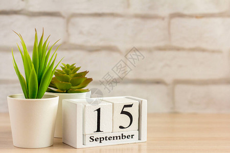 月15日在桌子或架子上的木制日历上秋季月份的一天9图片