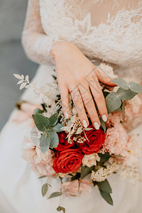 婚礼花束背景上带结婚戒指的新娘的手图片