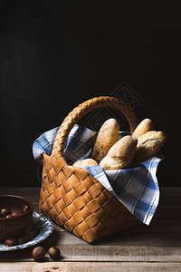 深色背景中篮子里的新鲜法式长棍面包图片