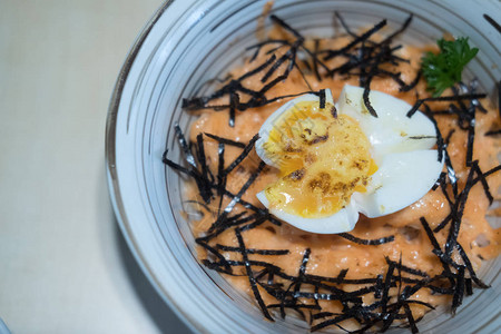 新鲜鲑鱼沙西米切片煮鸡蛋和陶瓷碗中图片