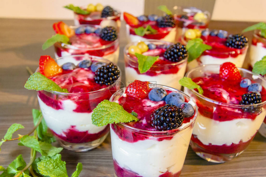 用草莓蓝莓薄荷格兰诺拉麦片桑葚在玻璃碗里吃酸奶健康食品和植图片